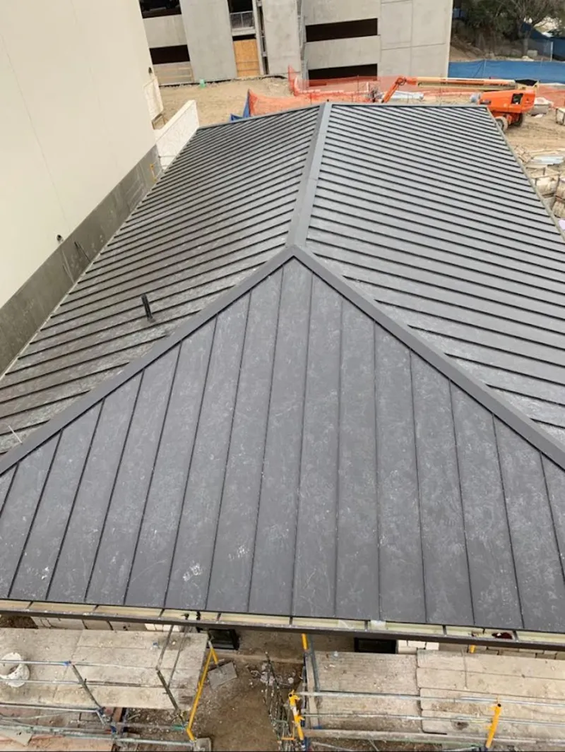 Commercial metal roof construction with crane equipment in Pittsburgh